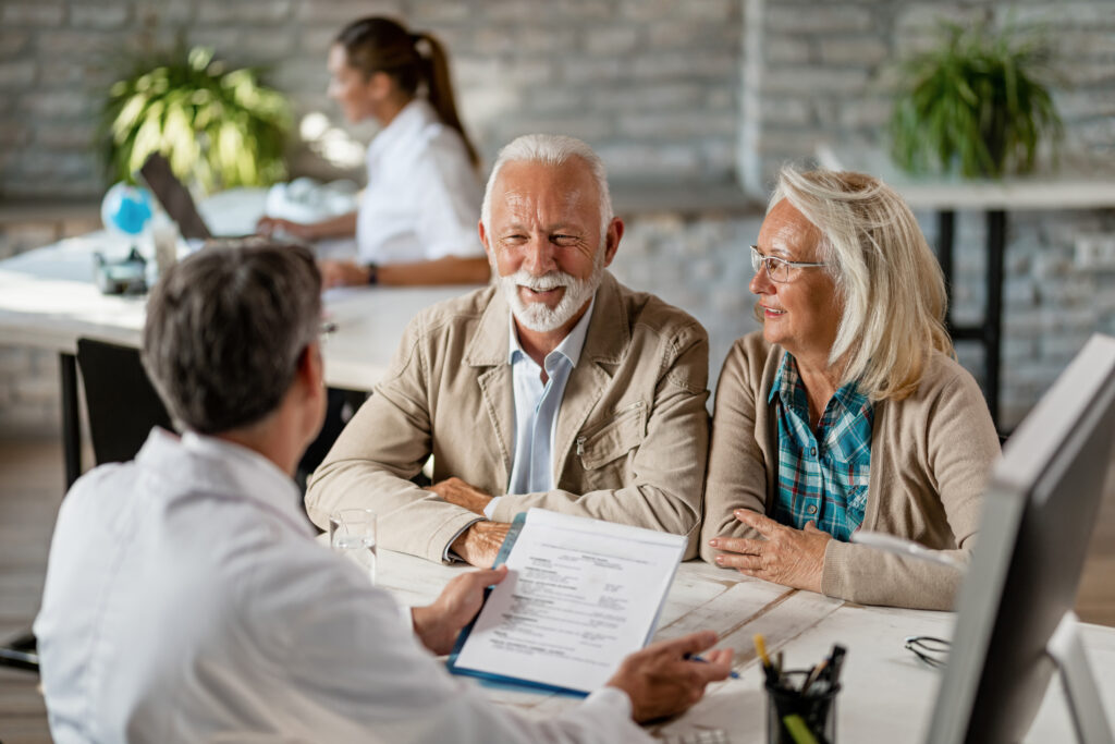 Senior couple discussing insurance coverage with an advisor during a consultation